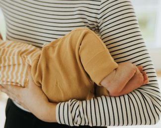 ostéopathe tenant un bébé. vue sur les pieds.